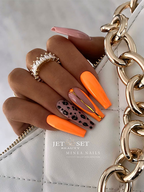 Long coffin orange nails with two accent nude nails one of them adorned with cheetah prints