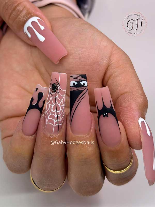 Long coffin-shaped nude Halloween nails with spooky eyes, black and white drip art, and spider web design on the ring finger.