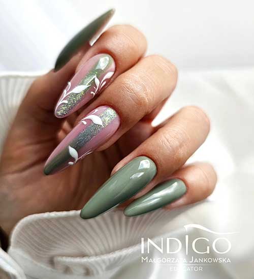 Dusty green trendy fall nails with two nude accent nails featuring holographic glitter and white leaf designs.