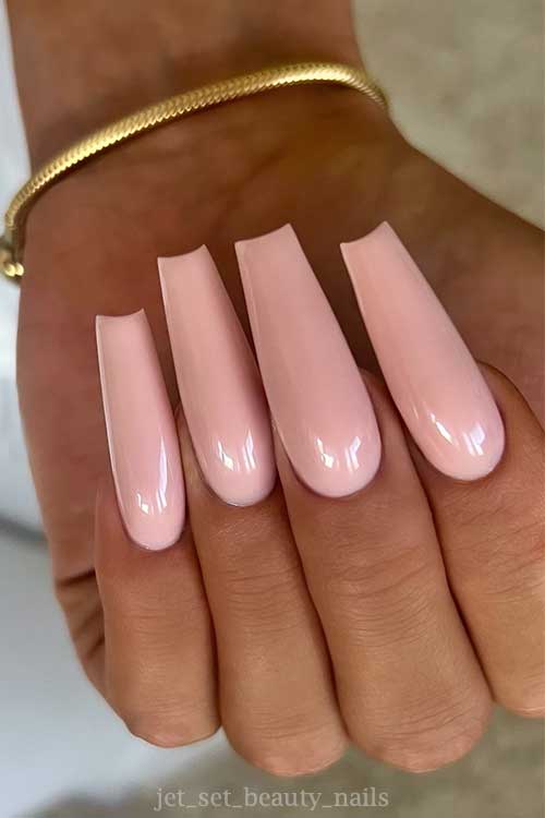 Elegant long coffin nails in a nude pink shade, embodying simplicity and style for a refined appearance.