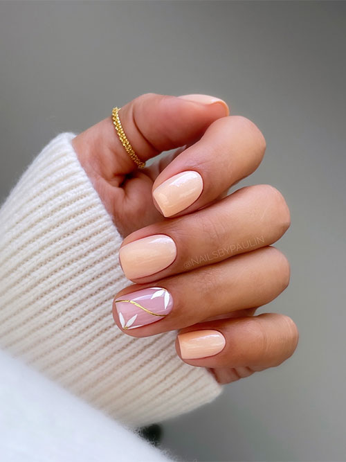 Soft short peach nails with a nude accent nail adorned with white flowers and a gold chrome swirl