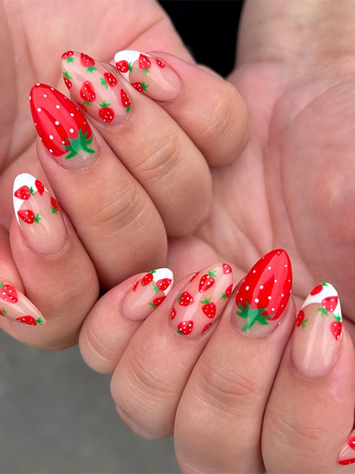 Long nude almond-shaped nails adorned with tiny strawberries with two accent white classic French tips