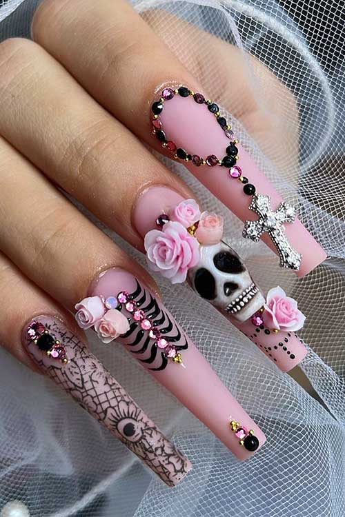 Long nude Halloween nails adorned with skulls, roses, and sparkling rhinestones for a festive look.