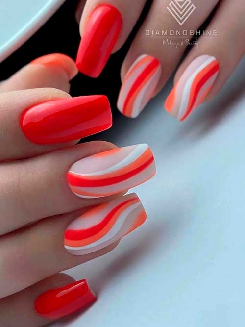 Red nails with orange, white, and red swirls on nude accent nails