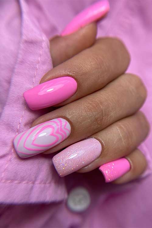 Long square shaped Barbie pink nails with glitter and heart shapes on a white accent nail
