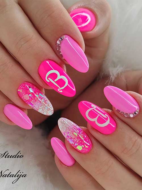 Short almond shaped different pink Barbie Logo Nails with glitter and rhinestones on accent nails