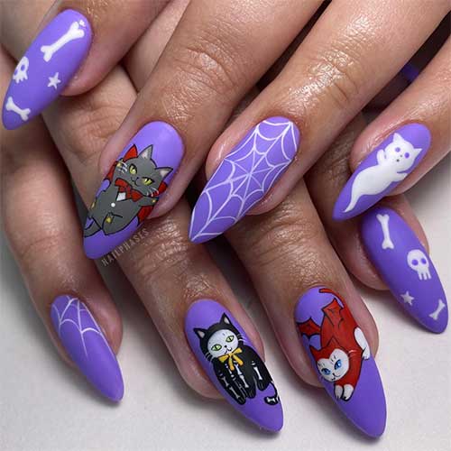 Long matte purple Halloween nails featuring a devil cat, skeleton cat, ghost cat, and white skulls and bones.