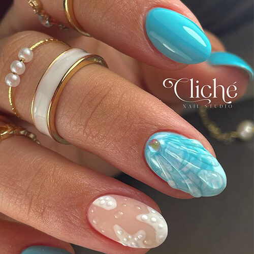 Short almond-shaped sky blue nails with water droplets nail art forming a mermaid nail art and adorned with a glass pearl