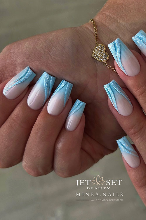 Long coffin baby blue ombre nails with design features gel baby blue swirls adorned with sugar glitter