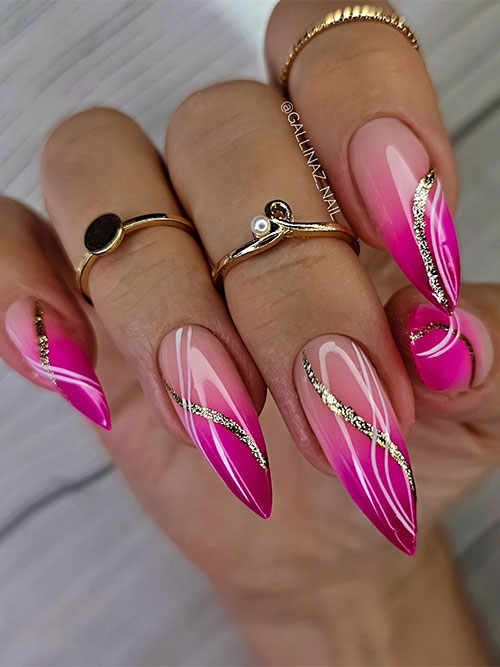 Long stiletto-shaped hot pink ombre nails adorned with chrome effect and gold glitter swirls