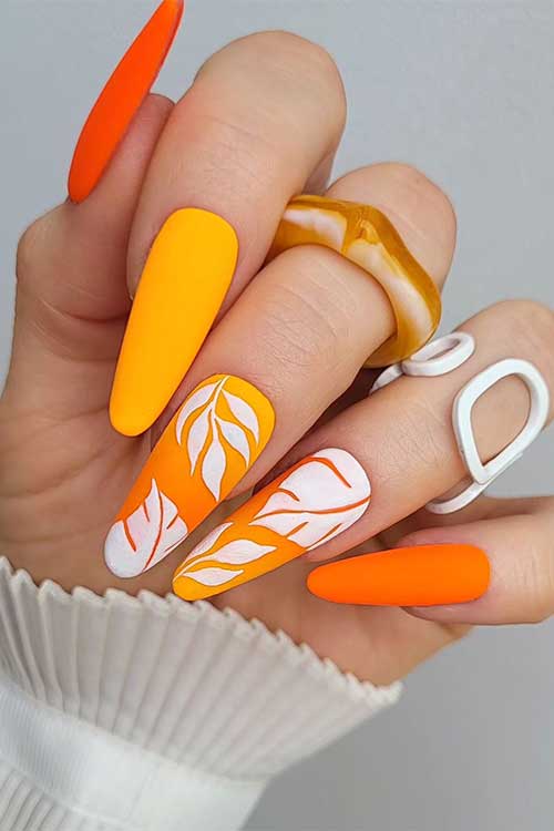 Light and Dark Neon Orange Nails with White Leaf Nail Art