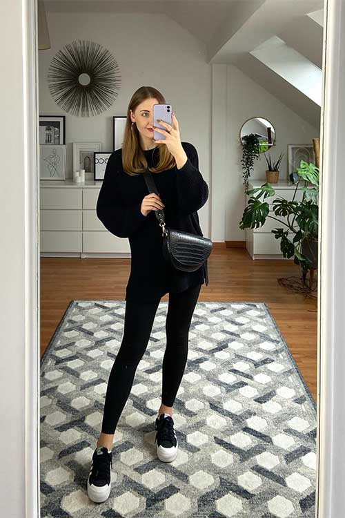 A stylish black oversized sweater paired with sleek black skinny leggings, creating a chic and comfortable outfit.