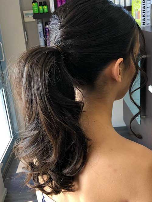 A puffy ponytail hairstyle, featuring soft, voluminous curls gathered at the back for a cozy and stylish look.