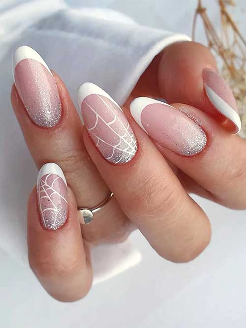 Classy Halloween French tip nails with silver glitter and spider web accents on two nails, perfect for a festive look.