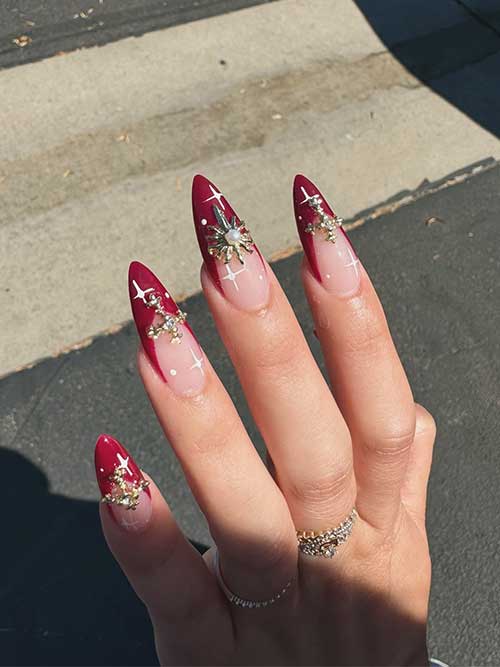 Long French burgundy nails on a nude base, adorned with white stars, dots, and sparkling rhinestones.