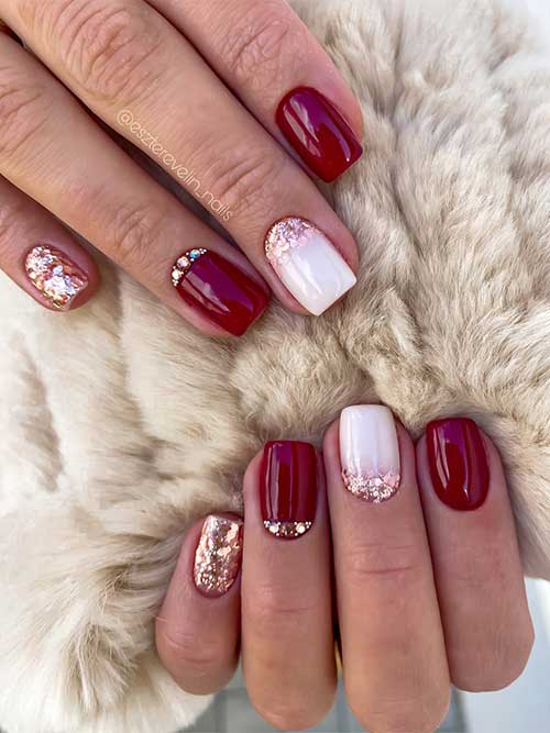 Short square burgundy nails with a glitter accent, milky white nail with glitter, and rhinestones on a burgundy accent nail.