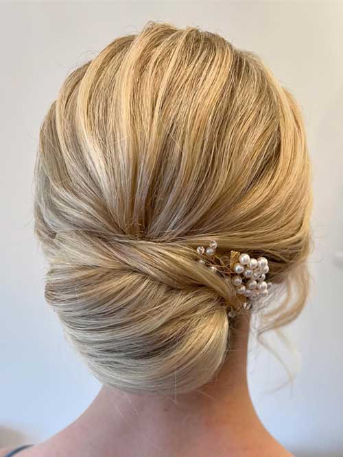 An elegant low chignon hairstyle with a neatly arranged bun at the nape, suitable for formal and special occasions.