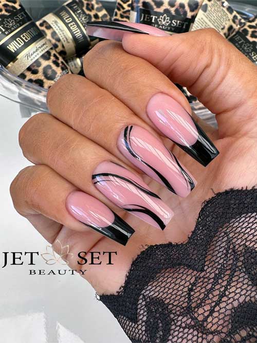 Elegant French fall black nails paired with two nude pink nails featuring intricate black swirl designs.