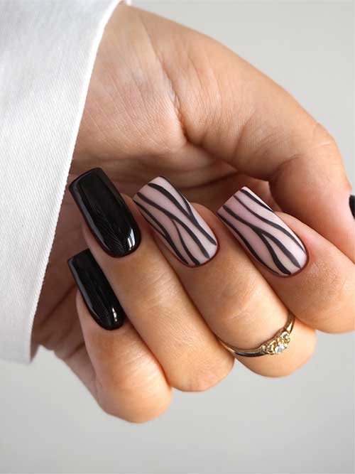 Elegant black nails paired with nude pink accents, adorned with matte black squiggly lines that mimic zebra patterns.