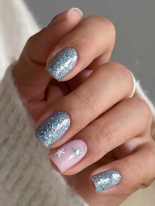 Elegant short frosty glitter winter nails 2024 with two accent nude pink nails decorated with white and frosty glitter stars.