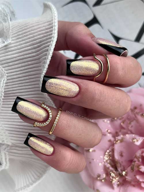 Festive fall black French manicure atop a shimmering gold glitter base, creating a striking and elegant nail design.