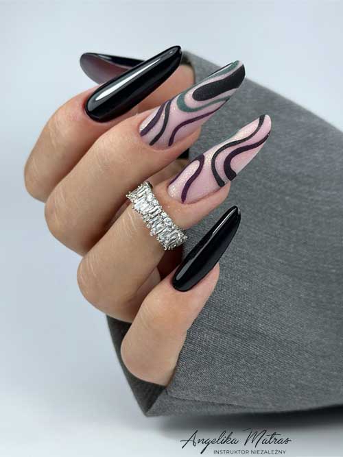 Long black nails with swirl art, complemented by two nude pink accent nails adorned with glitter.