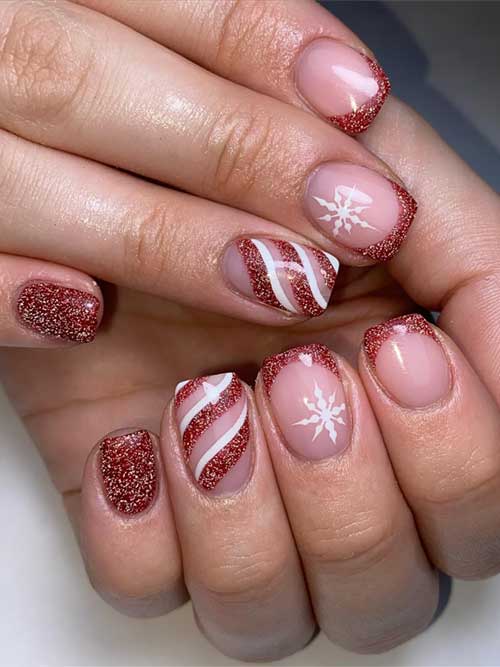 Short dark reddish-brown French nails adorned with gold glitter, candy cane, and snowflake designs for a festive Christmas look.