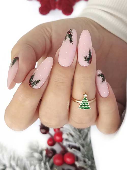 Classy matte nude almond-shaped nails featuring holly leaves and white polka dots for a festive Christmas look.