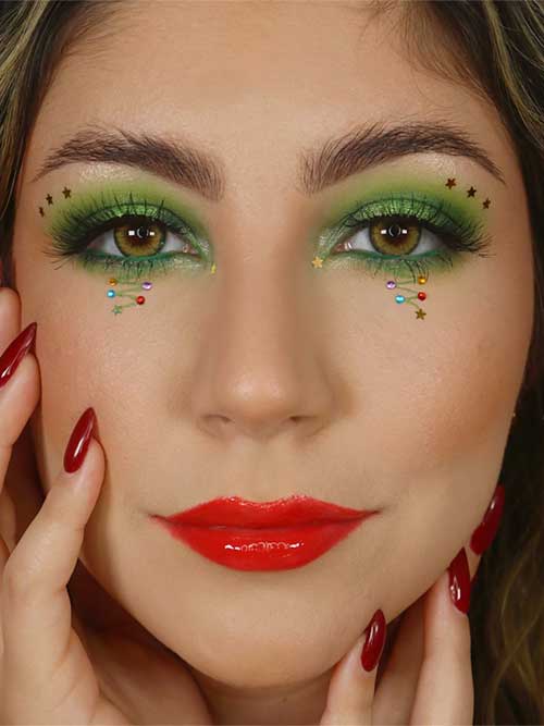 Glittering green Christmas eye makeup paired with glossy red lips, creating a festive and vibrant holiday look.