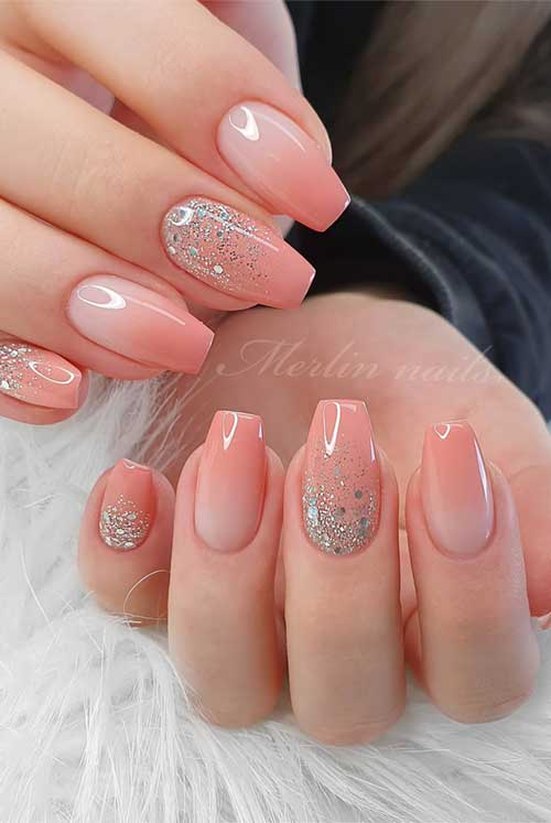 Feminine peachy-pink nails featuring a gradient design and silver glitter accents, radiating elegance and freshness.