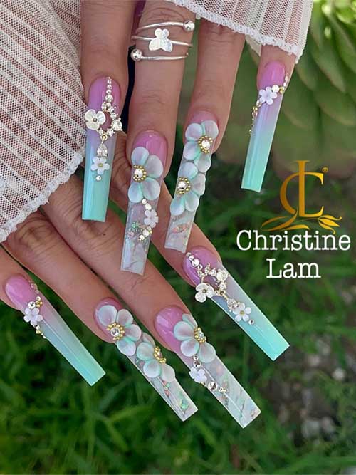 Ombre pastel nail art featuring a pink to turquoise gradient, floral embellishments, and rhinestones for a spring-inspired look.